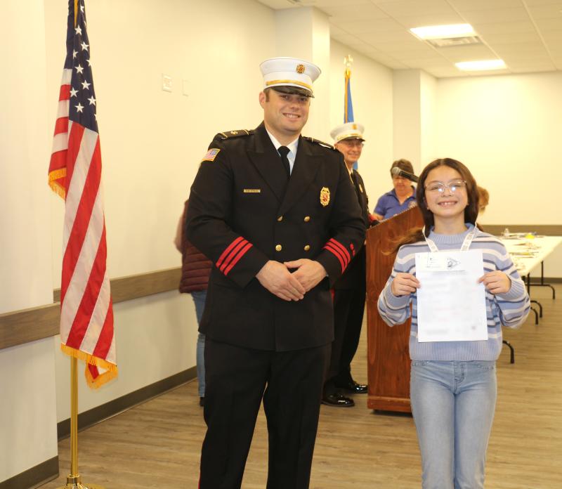 Delmarva Christian fourth-grader Lexi Miranda celebrates her third-place win with MFD President Brian Reynolds Jr.